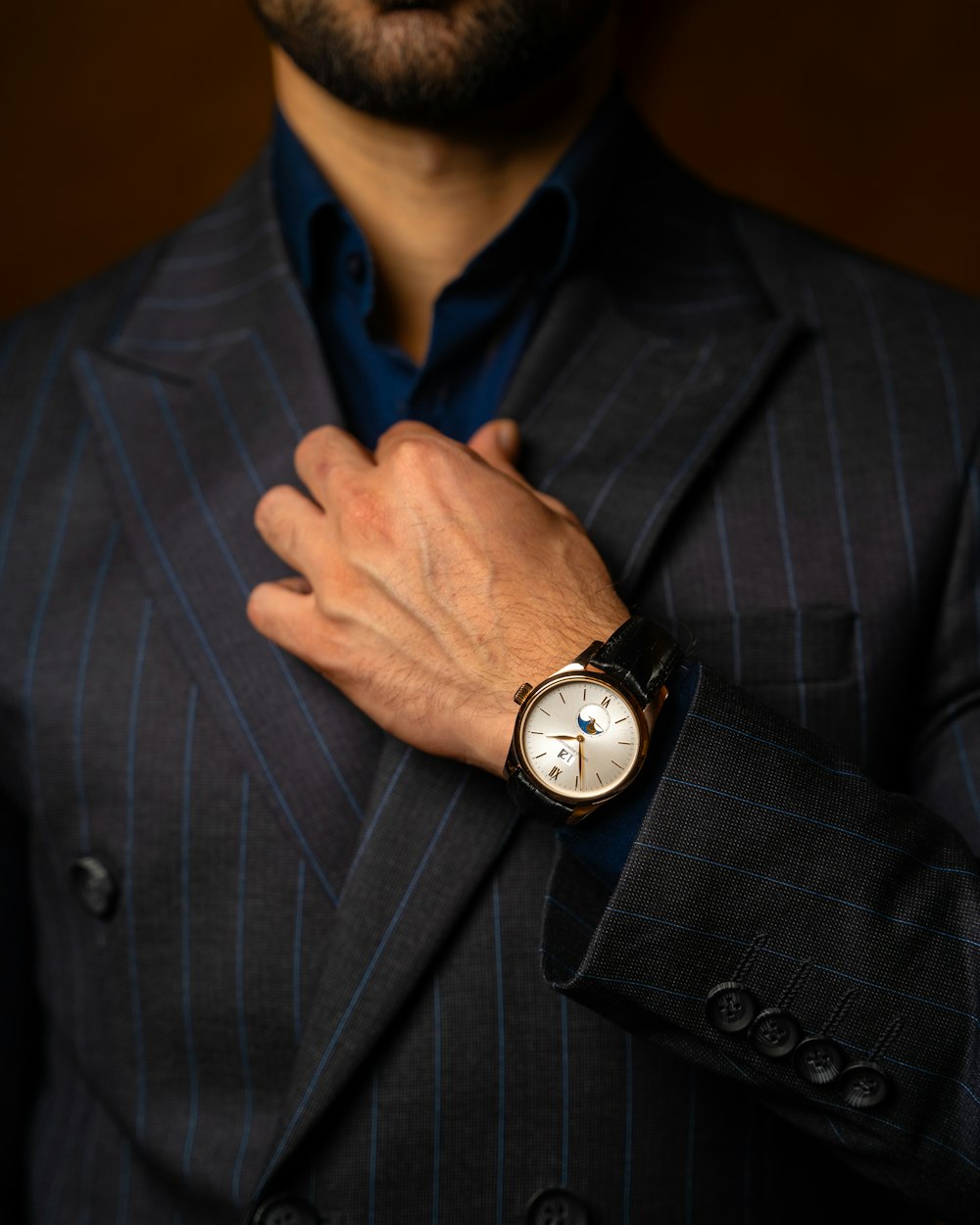 a man in a suit with a watch on his wrist