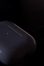 Close-up of advanced PEMF device emitting soft red light in a minimalist studio setting.