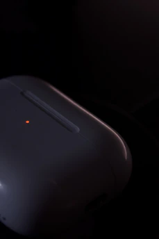 Close-up of advanced PEMF device emitting soft red light in a minimalist studio setting.