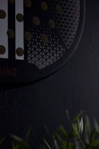 Close-up of a precision-engineered water-saving device installed on a modern showerhead in a hotel bathroom.