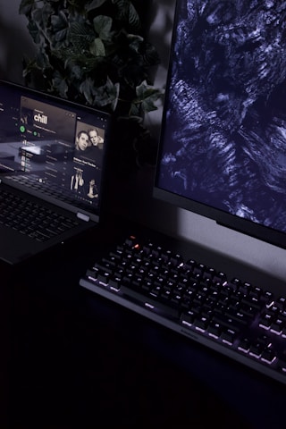 A sleek dark-themed workspace with a laptop displaying music analytics and electric blue accents glowing softly.