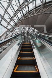 an escalator in a building with a glass ceiling