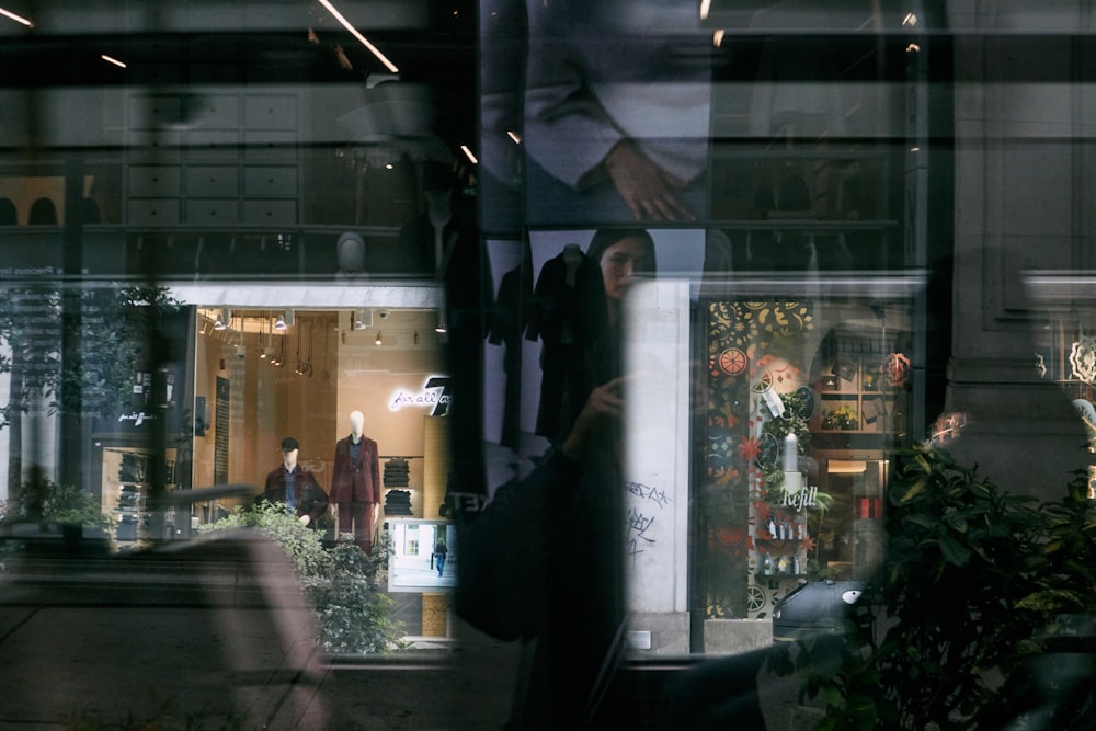 a store front with a reflection of a man in the window