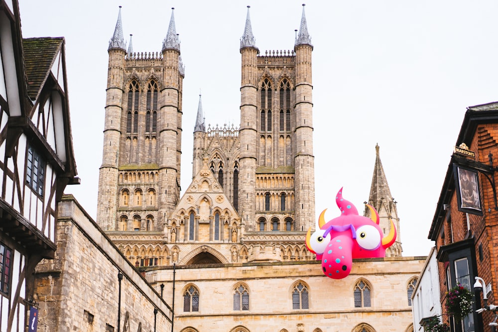 a large building with a giant pink monster on top of it