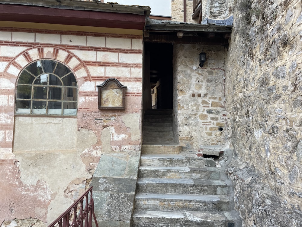 a stone building with steps leading to a window