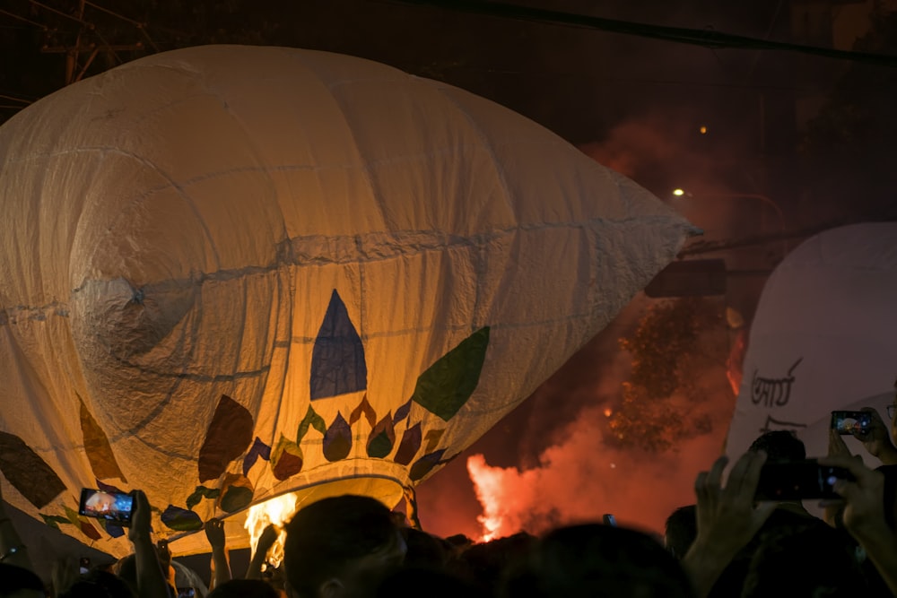 un gruppo di persone in piedi intorno a una grande mongolfiera