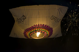 Colorful lanterns floating into the night sky during a traditional Thai festival celebration.