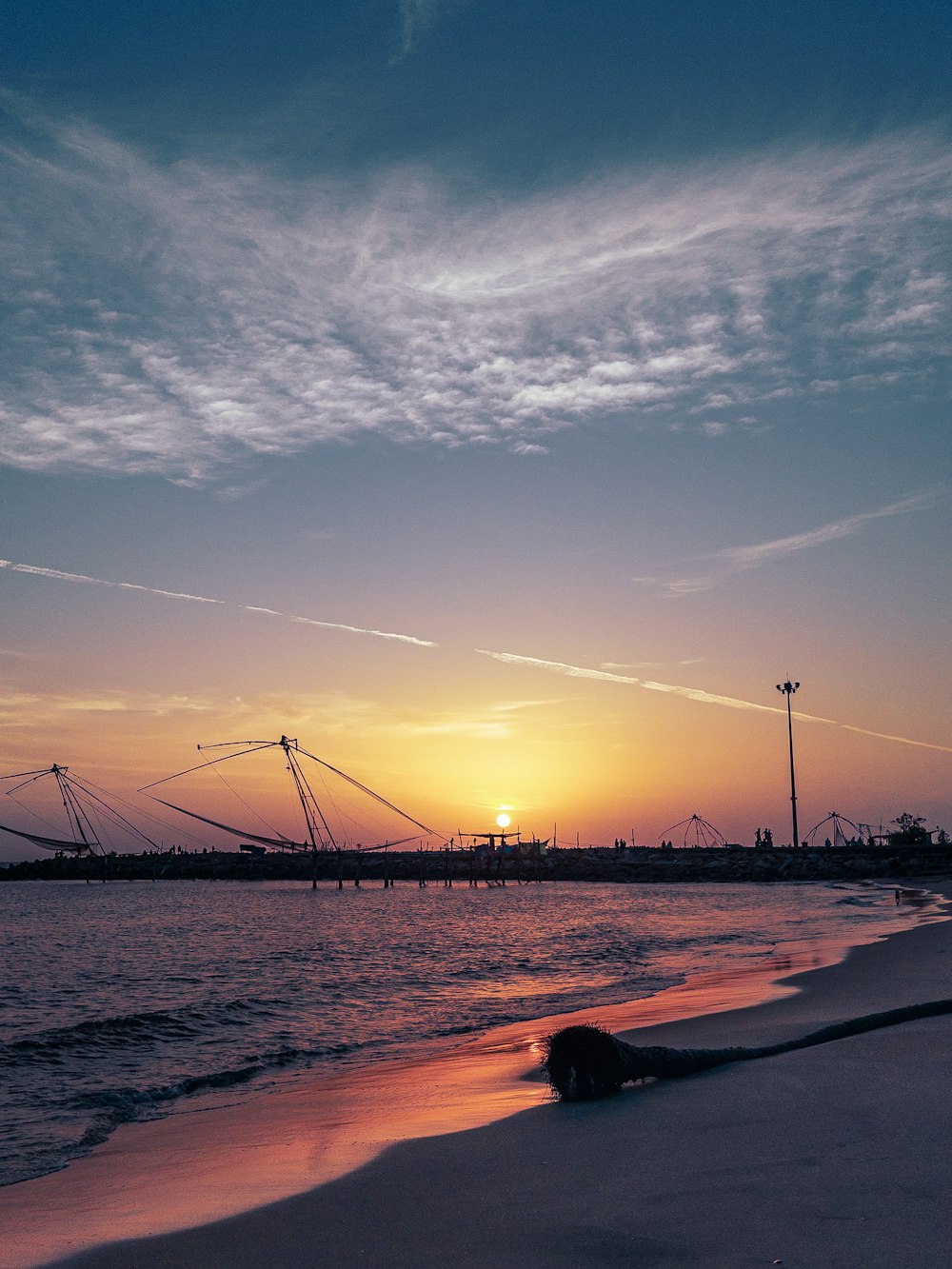 the sun is setting over the water at the beach