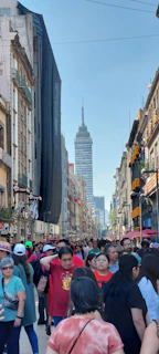 A vibrant street scene in Hong Kong with businesspeople walking past towering glass skyscrapers under a clear blue sky.