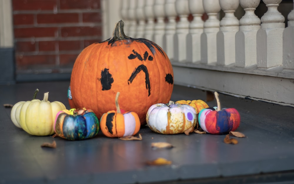 a group of painted pumpkins sitting on a porch