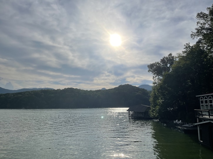 Sunlight glistening on the serene lakefront with the mid-century modern rental house in view.
