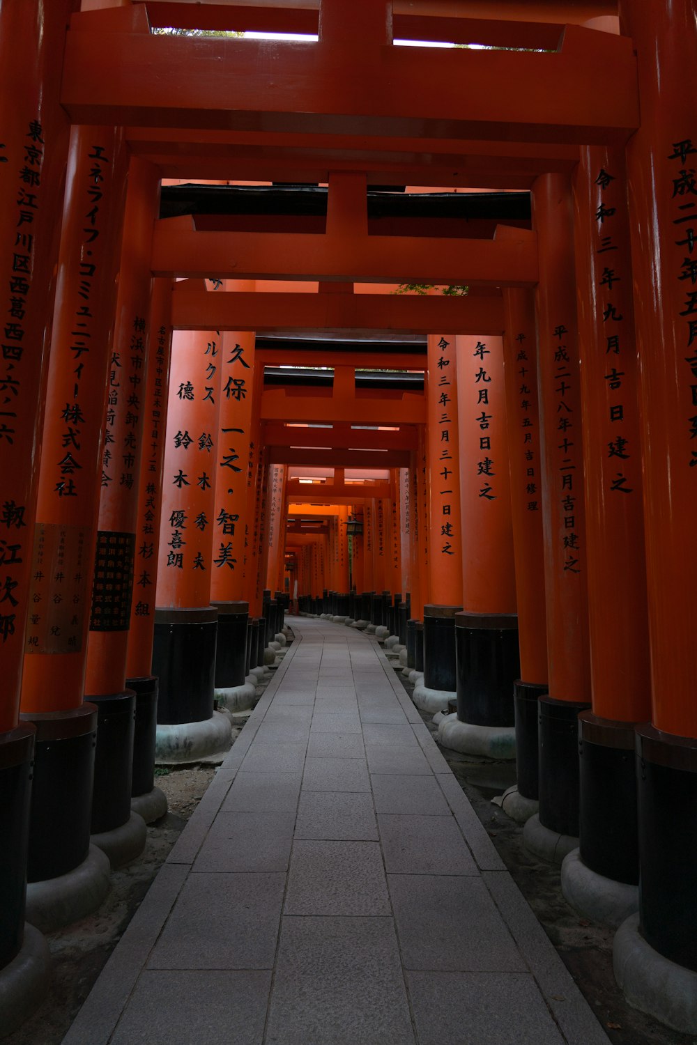 a walkway lined with orange and black columns