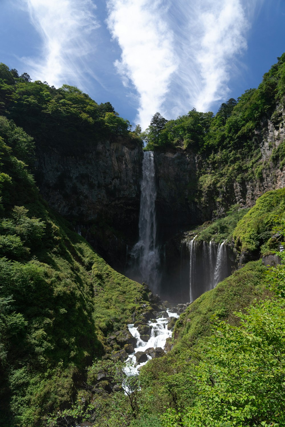 a waterfall in the middle of a lush green valley