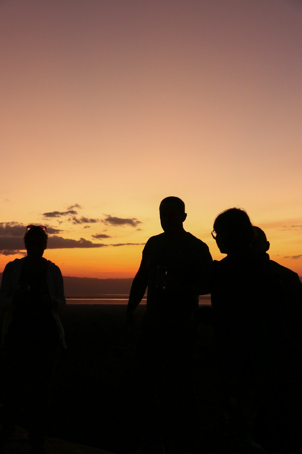 a group of people standing next to each other at sunset