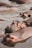 A group of hippos partially submerged in water, with most of their bodies underwater and only their heads and backs visible. The water appears murky and brownish in color, and the hippos are close together, showing a sense of togetherness and calmness.
