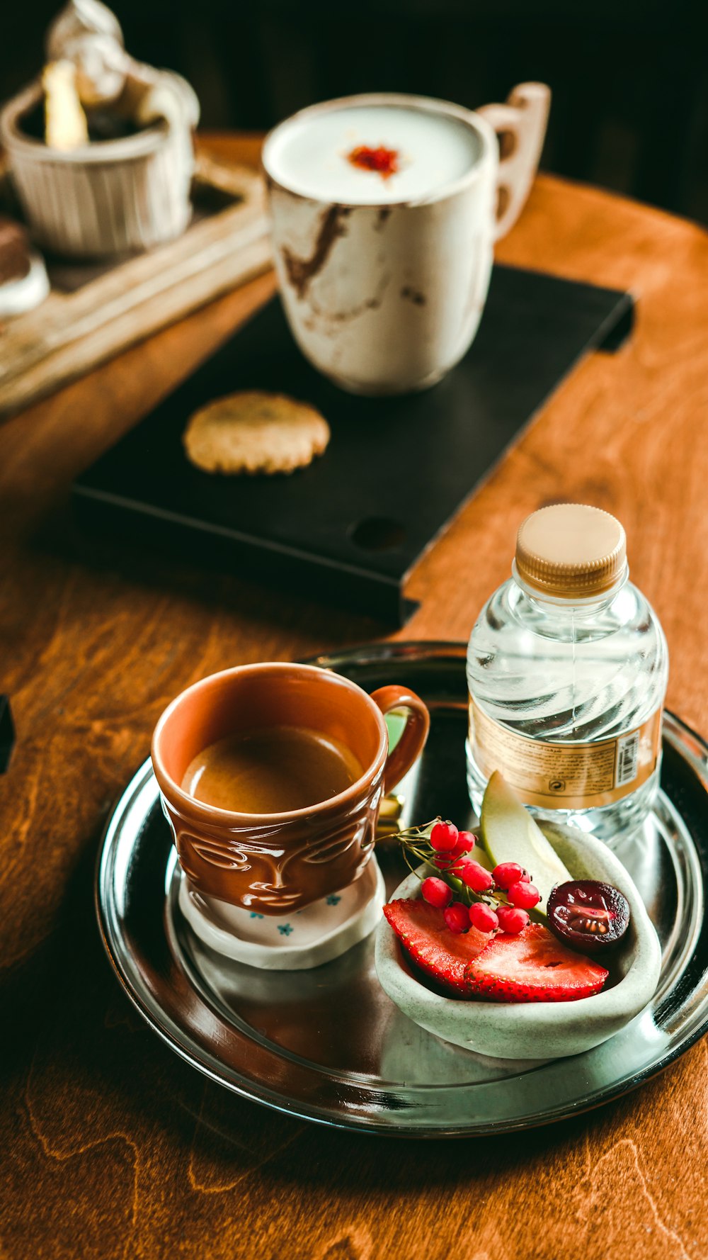 a wooden table topped with a plate of food and a cup of tea