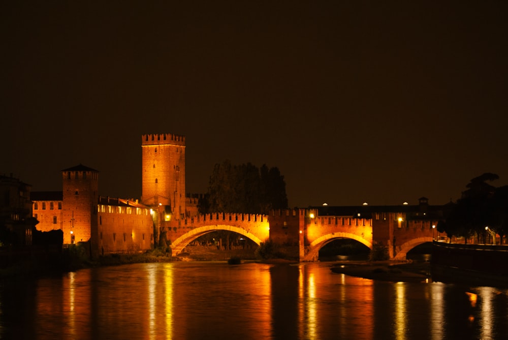 a bridge over a body of water with a castle in the background