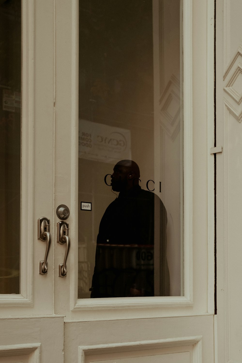 um homem parado em frente a uma porta branca