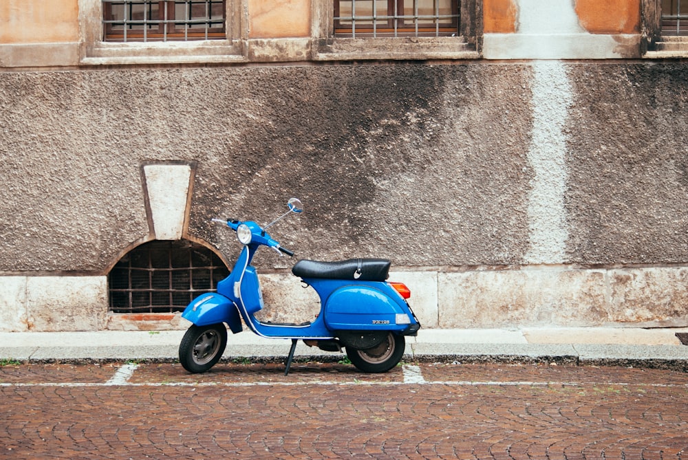 uma scooter azul estacionada em frente a um prédio