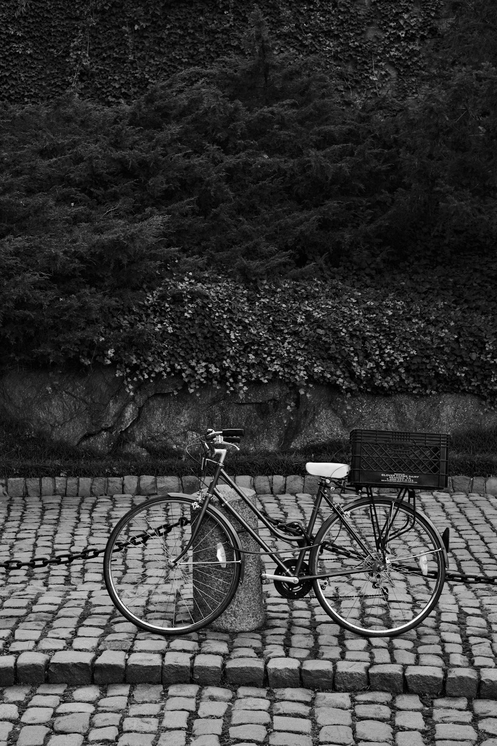 a bicycle parked on a brick sidewalk next to a park bench