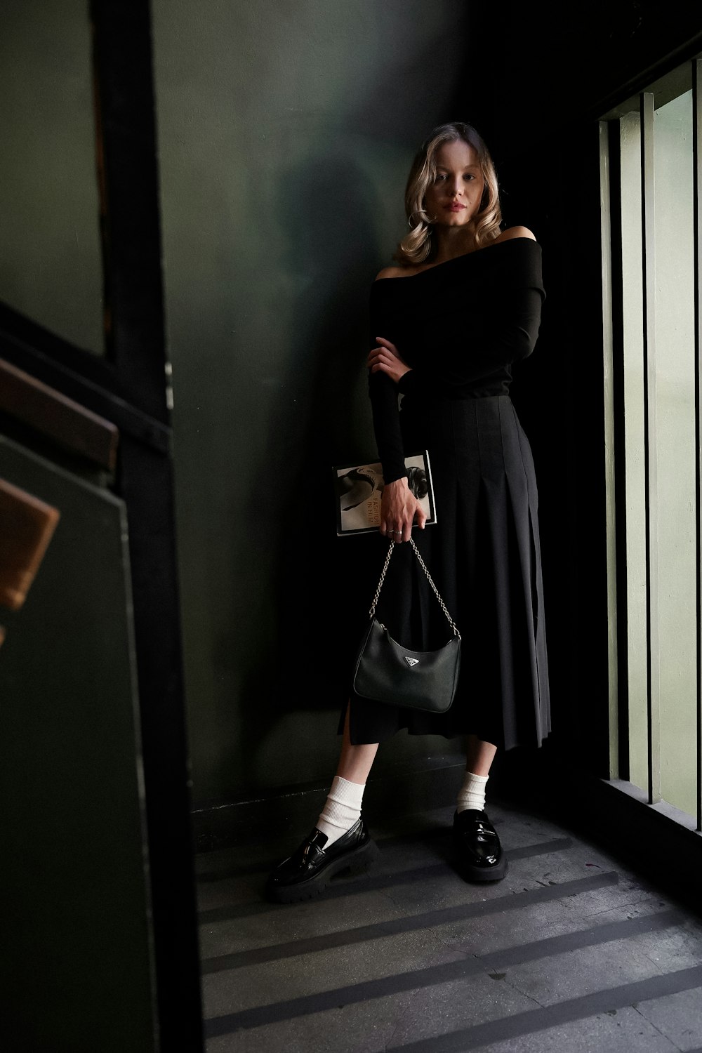 a woman in a black dress holding a purse