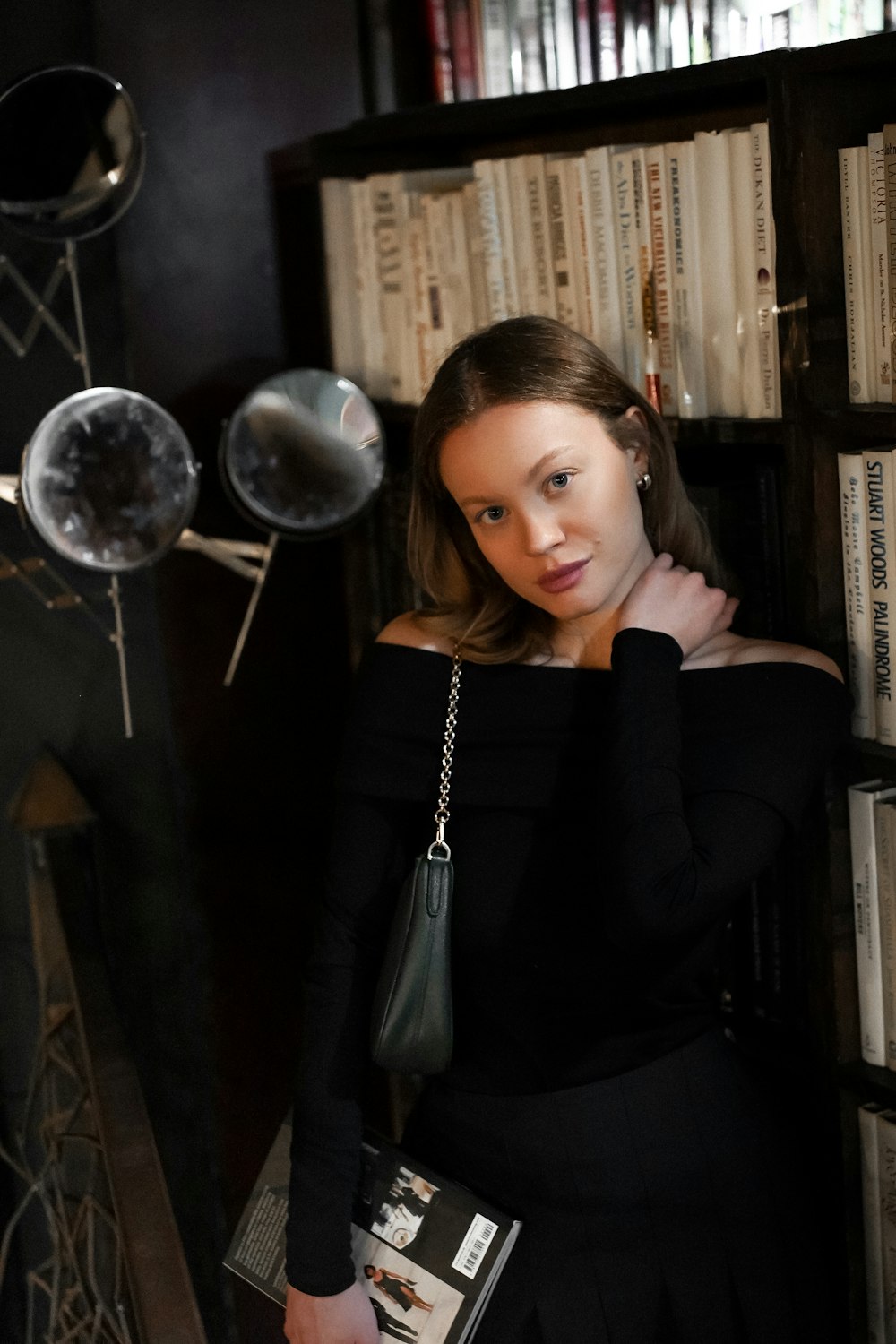 a woman standing in front of a book shelf