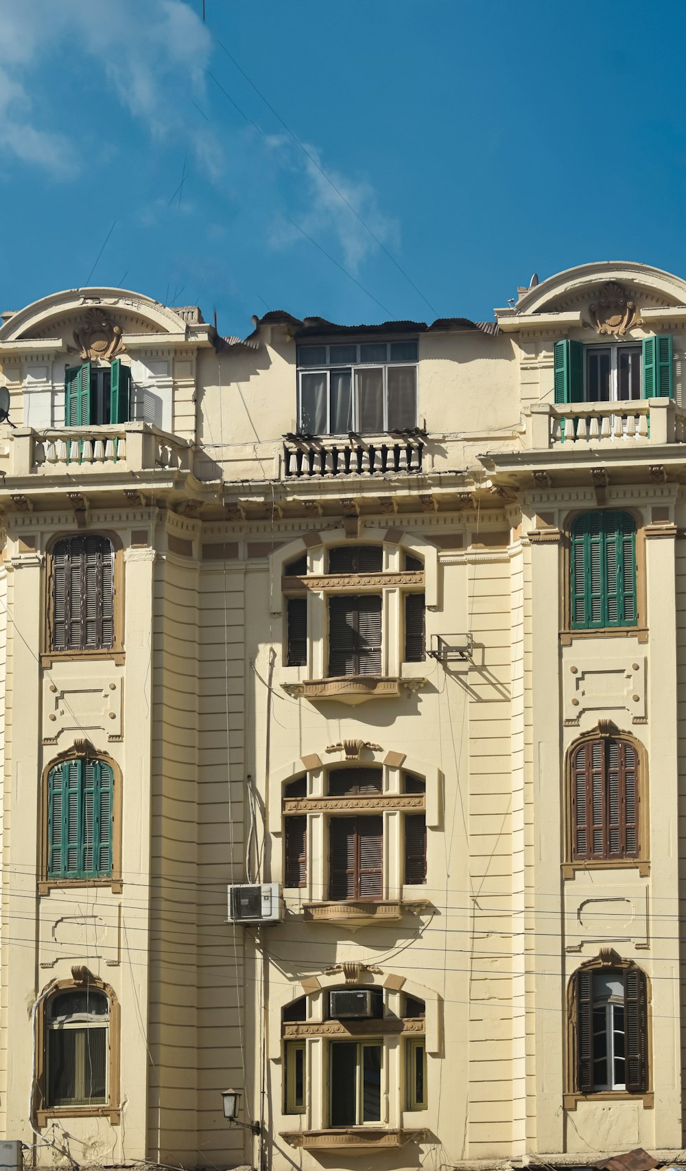 an old building with green shutters and balconies
