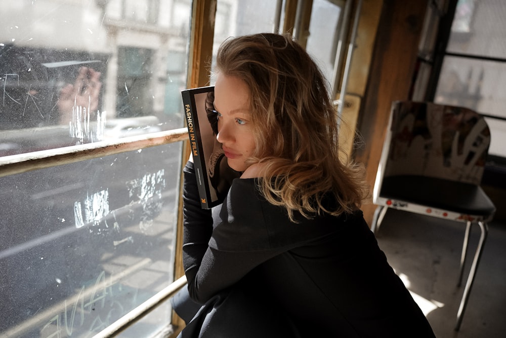 a woman looking out the window of a train