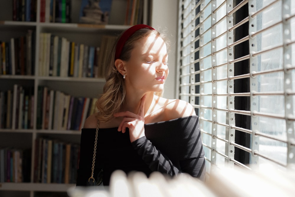 a woman standing in front of a book shelf