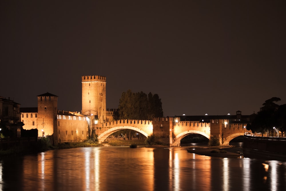 a bridge over a body of water with a castle in the background