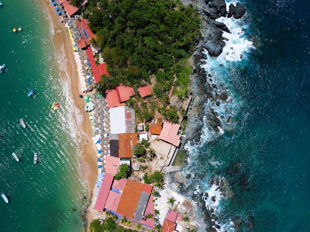 an aerial view of a beach with boats in the water