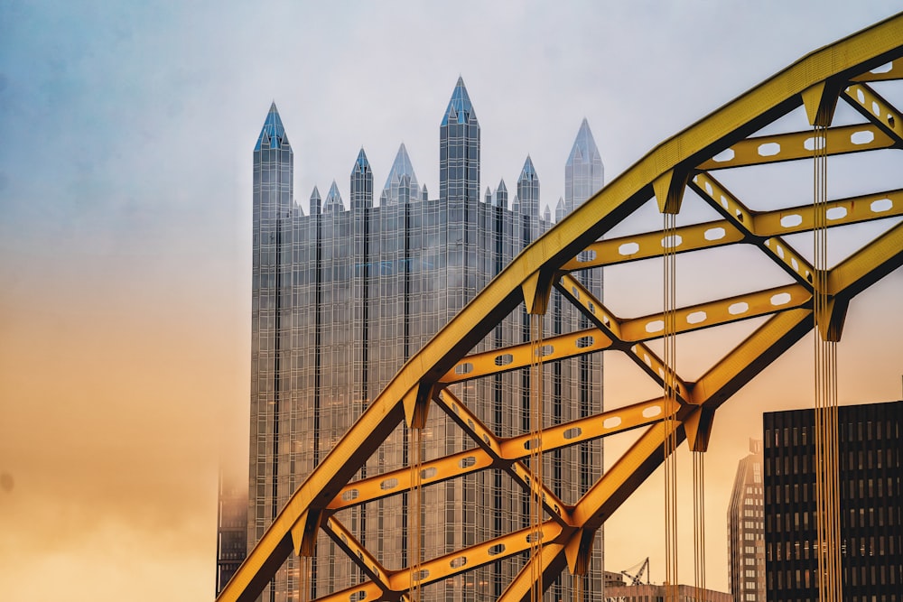 un ponte giallo con un alto edificio sullo sfondo