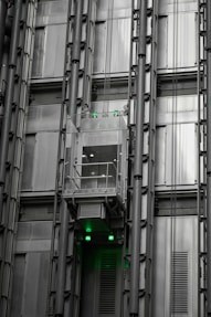 a tall building with lots of windows and green lights