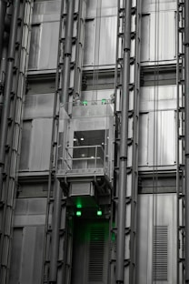 a tall building with lots of windows and green lights