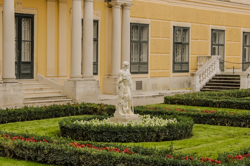 a statue in a garden in front of a building