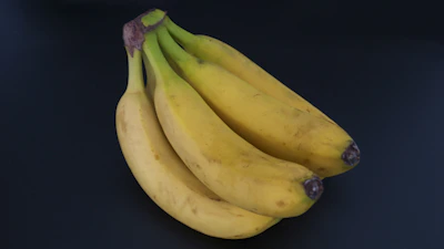 A bunch of ripe Cavendish bananas resting on a market stall.