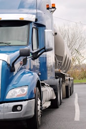 a blue semi truck driving down a street