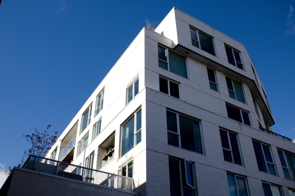 a tall white building sitting next to a tall building