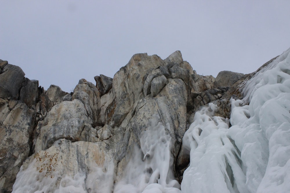 a large rock formation covered in ice on a cloudy day