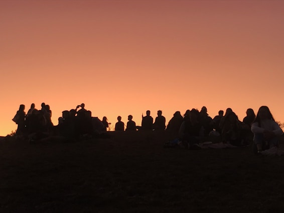 A group of happy travelers sharing a sunset view on a scenic hilltop, capturing the essence of togetherness and adventure.