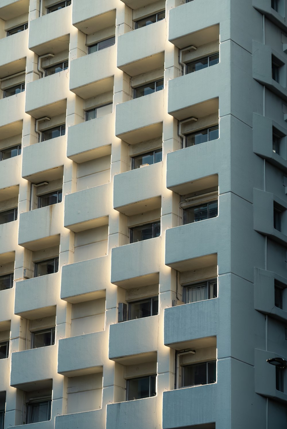 a tall white building with balconies and windows