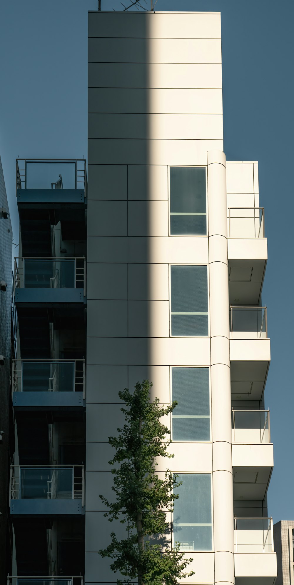 a tall building with balconies and a clock on top