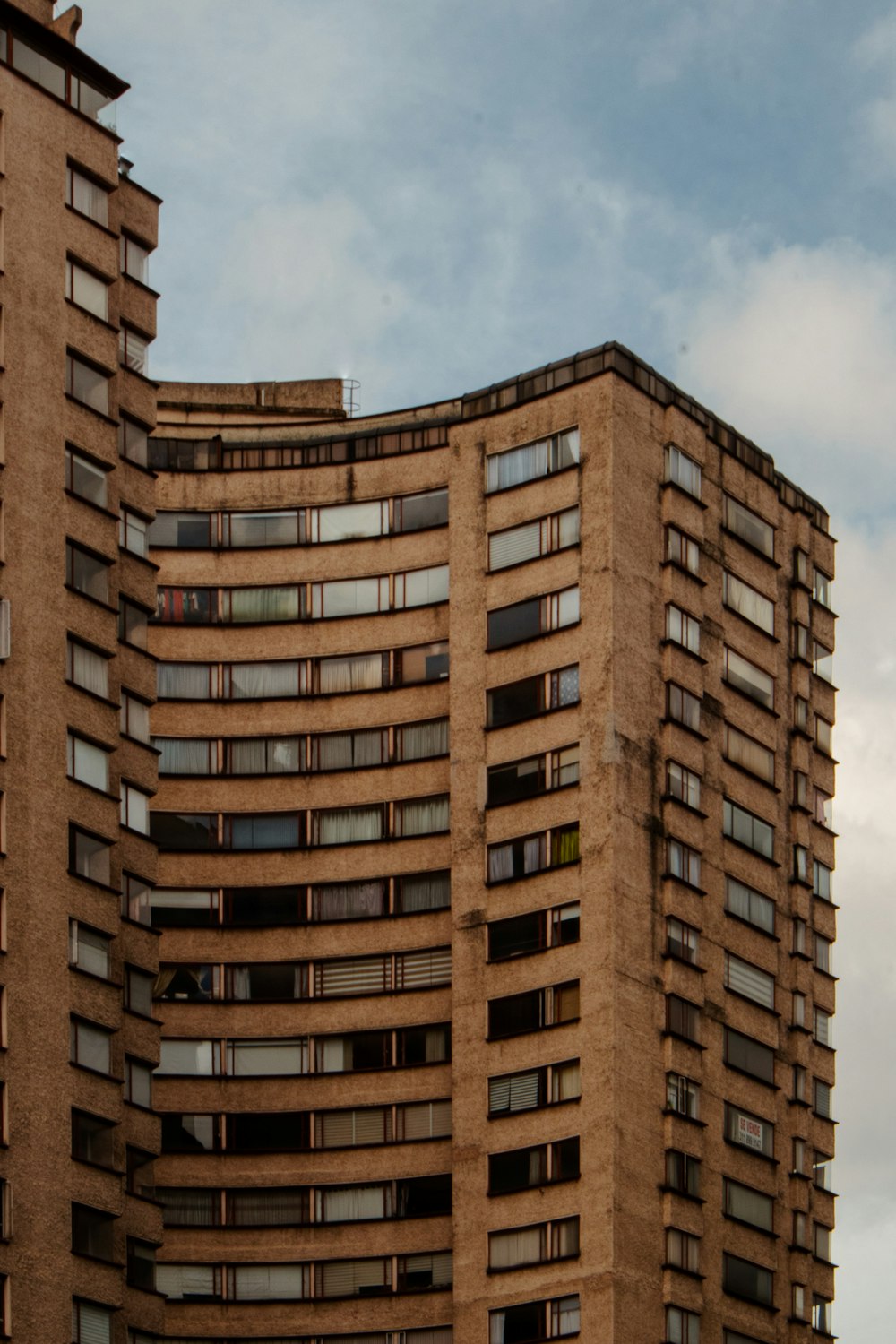 a tall brown building with lots of windows