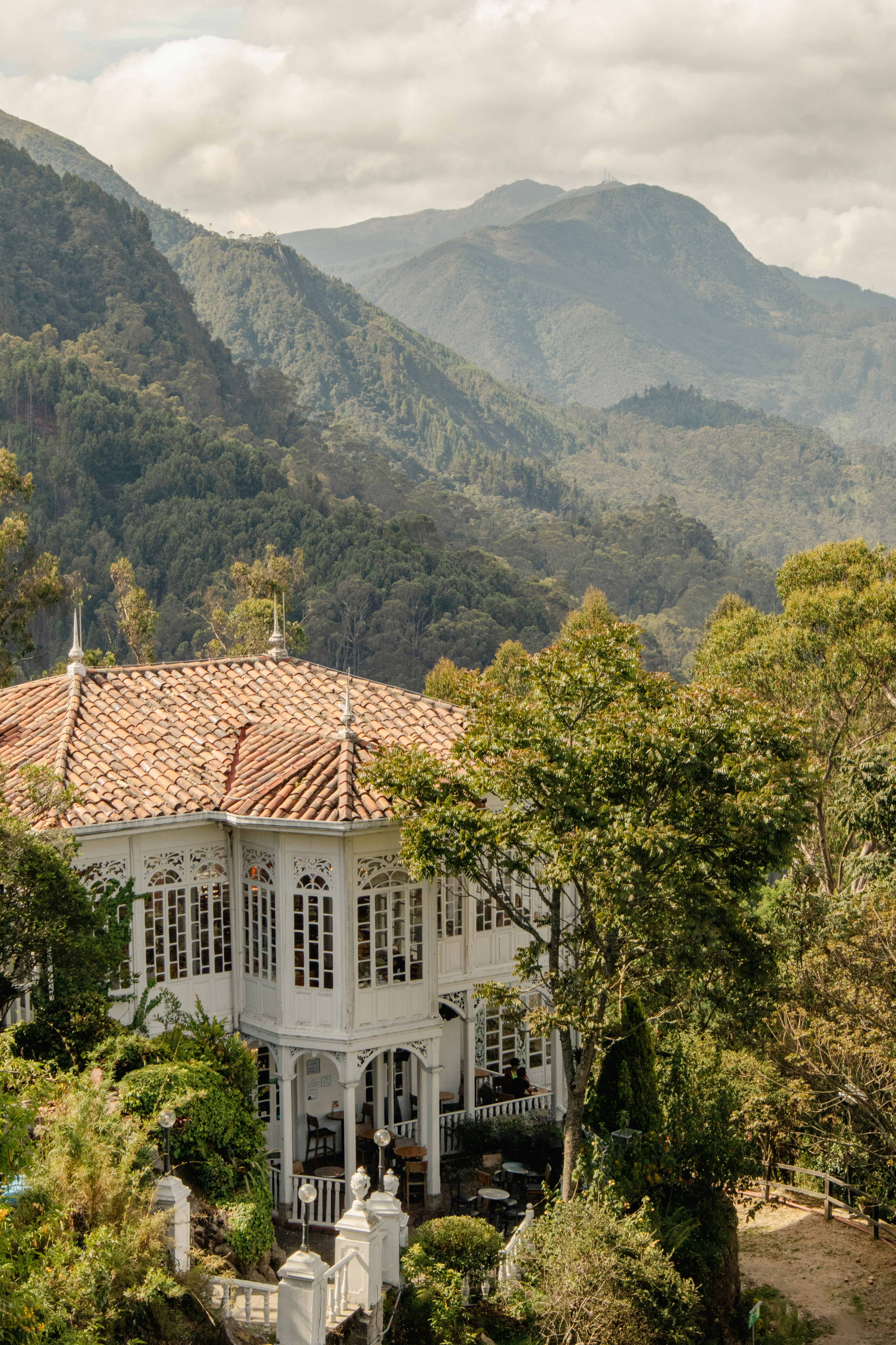 a large white house surrounded by trees and mountains