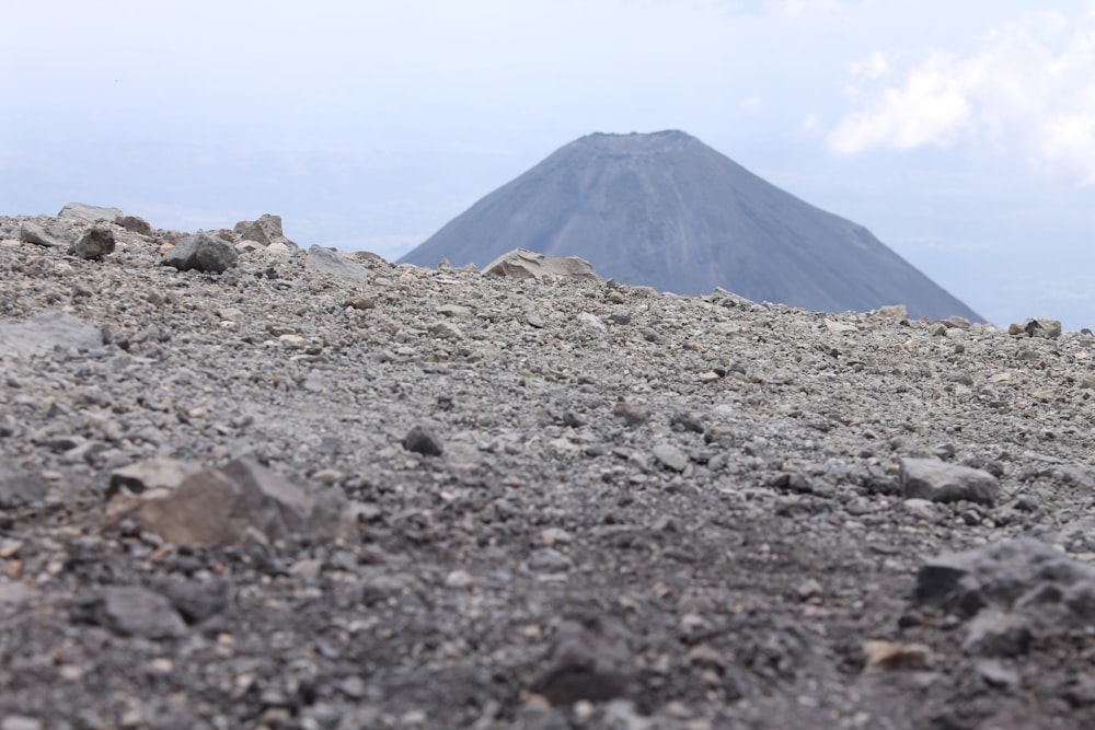 a rocky area with a mountain in the background