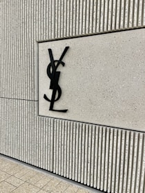 Close-up of a wooden textured wall with black elegant logo lettering for cmendes events.