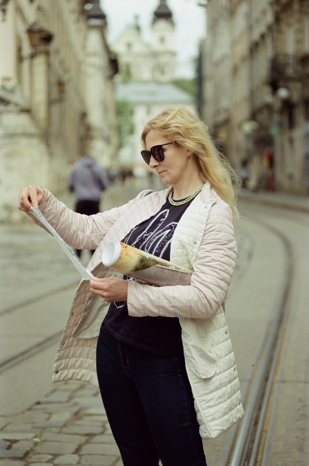 a woman in a white jacket is holding a paper