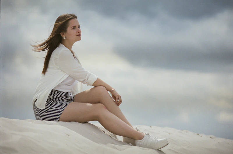 Relaxed BBW woman sitting on a sandy beach