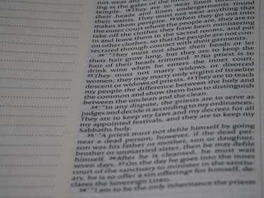 A close-up photograph of a printed page from a book. The text is formatted in a column, with paragraphs detailing religious or historical instructions related to priests. The page includes both printed text and a blank section on the left with a series of dotted lines, possibly for notes or annotations.