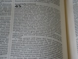 A close-up of an open book with text printed on its pages. The text includes a numbered heading and detailed information organized in paragraphs. The visible text is discussing the allocation of land. The title 'Israel fully restored' is prominent.